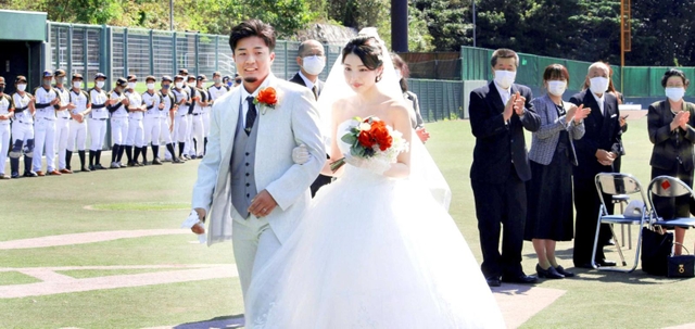 家族や選手から祝福されて退場する新郎新婦＝三田市三輪