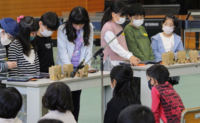 タブレットを操作しロボットから「かえるの合唱」を流す児童＝志手原小学校