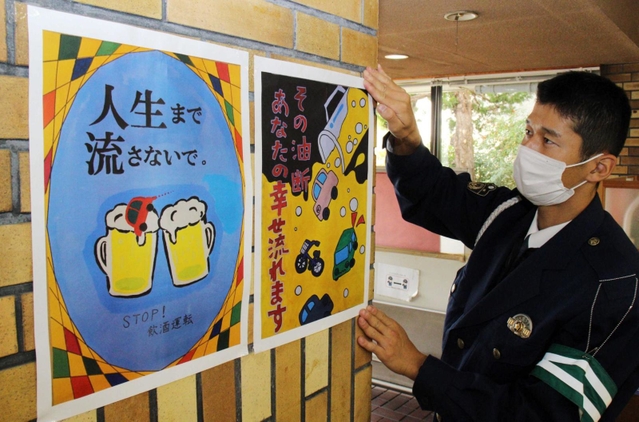 市内の子どもたちが描いたポスターを掲示する三田署員＝三田署