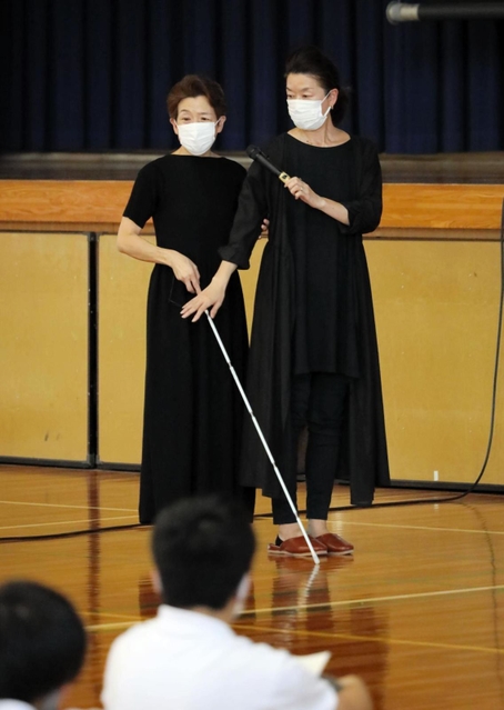 白杖（はくじょう）を持つ岡崎明美さん（左）＝三田市ゆりのき台３