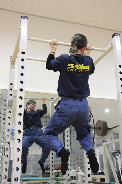 「何かしてないと不安になるんです」。懸垂で腕を中心に鍛える＝三田市消防本部