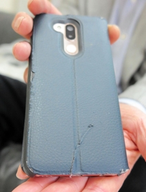 イノシシにかみつかれたスマートフォンのカバー。腹部あたりのポケットに入れており、なければさらに重傷を負っていた可能性もある