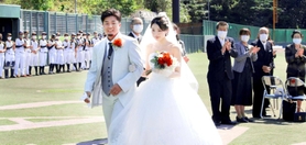 家族や選手から祝福されて退場する新郎新婦＝三田市三輪