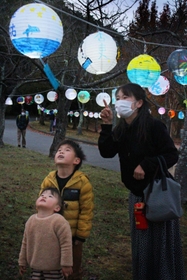 ちょうちんを見上げる親子＝三田谷公園
