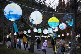 色とりどりのちょうちんを見上げる親子連れら＝三田谷公園