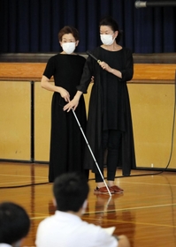 白杖（はくじょう）を持つ岡崎明美さん（左）＝三田市ゆりのき台３