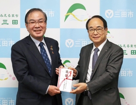 森哲男市長（左）に目録を手渡す日本フレーバー工業の上木邦彦社長＝三田市役所