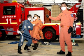 救助隊の先輩と３倍力滑車の仕組みを使った訓練＝三田市消防本部