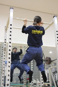 「何かしてないと不安になるんです」。懸垂で腕を中心に鍛える＝三田市消防本部