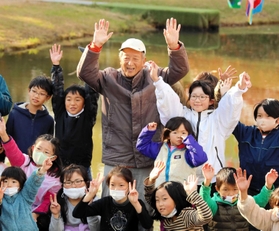 子どもたちに囲まれる新宮晋さん＝三田市尼寺