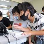 教え合いながらゲームを作る児童＝志手原小学校