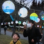 ちょうちんを見上げる親子＝三田谷公園