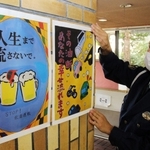 市内の子どもたちが描いたポスターを掲示する三田署員＝三田署