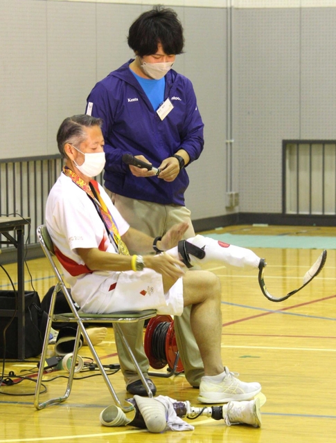 義足の付け方を説明する松本功さん（手前）と唐内健太さん＝三田市志手原