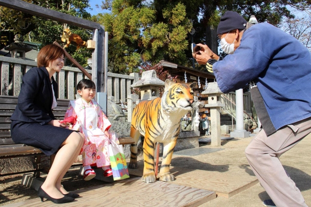 本物そっくりな虎の置物と記念撮影＝三田市天神３