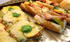 チーズがあふれるピザやウインナーをまるごと２本はさんだパン＝三田市下井沢