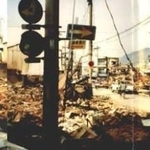 震災直後、満福寺から鷹取商店街を見渡す。がれきの山を前に、荷物を抱えた人たちが立ち尽くす＝神戸市長田区海運町４（山下さん提供）