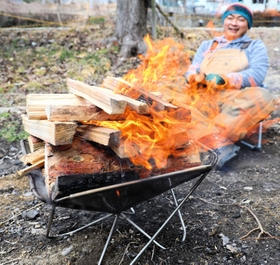 たき火に思わず見入り、笑顔になる＝三田市野外活動センター