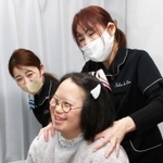 芝田恵子店長（右）からマッサージを受ける竹内綾菜さん＝三田市相生町