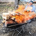 たき火に思わず見入り、笑顔になる＝三田市野外活動センター