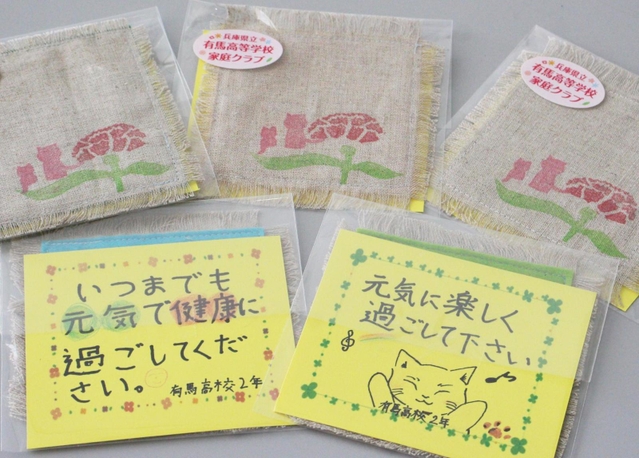 生徒手作りのコースターにメッセージカードが添えられている＝三田市川除
