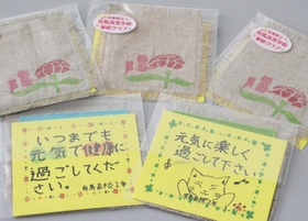 生徒手作りのコースターにメッセージカードが添えられている＝三田市川除