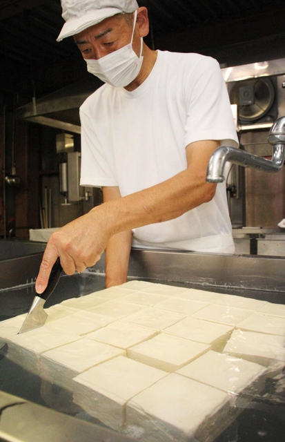 厚揚げにする豆腐を切り分けていく＝三田市大川瀬
