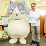 三田市立図書館ウッディタウン分館を訪れ、東和久館長（右）に絵本を手渡すマル＝三田市けやき台１