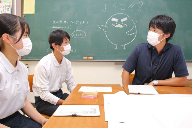 橋本教諭（右）と打ち合わせをする生徒会役員＝狭間中学校