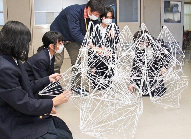 三角すいを規則的に組み合わせていく＝藍中学校