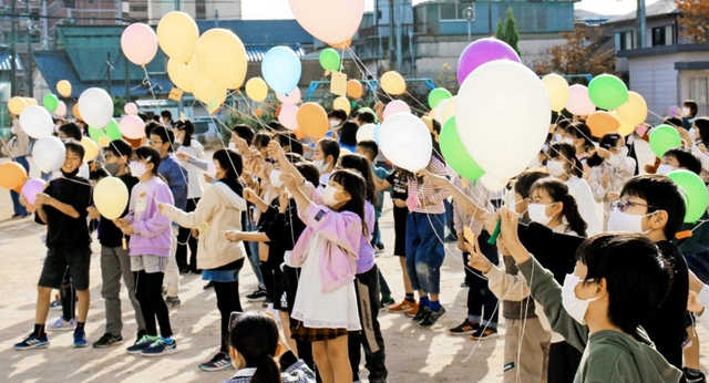 創立１２０年を祝い風船を飛ばす児童＝三輪小学校