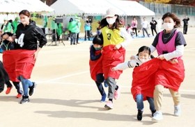 「でかパン」リレーを楽しむ親子ら＝三田市けやき台２