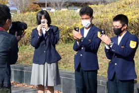 斎藤記者からカメラの構え方を教わる（右から）中村さん、松本さん、安井さん＝三田市福島