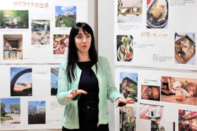 展示された写真を前に話すカテリーナさん＝市まちづくり協働センター
