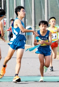男子・けやき台の４区脇水康佑選手（左）からたすきを受け取って走り出す５区澤泉光選手＝豊岡市日高町（撮影・長嶺麻子）