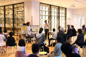 標本が並ぶ会場で、三橋弘宗主任研究員が曲の内容に沿った解説を披露した＝県立人と自然の博物館