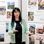 展示された写真を前に話すカテリーナさん＝市まちづくり協働センター