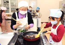 三宅さん（左）に教わりながら調理にチャレンジする子ども＝三田市武庫が丘７