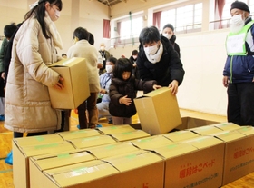 ダンボールベッドを組み立てる子どもたち＝松が丘小学校