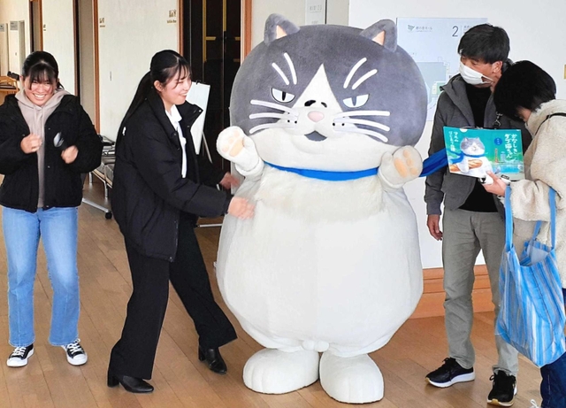 マルと記念撮影する来場者＝三田郷の音ホール
