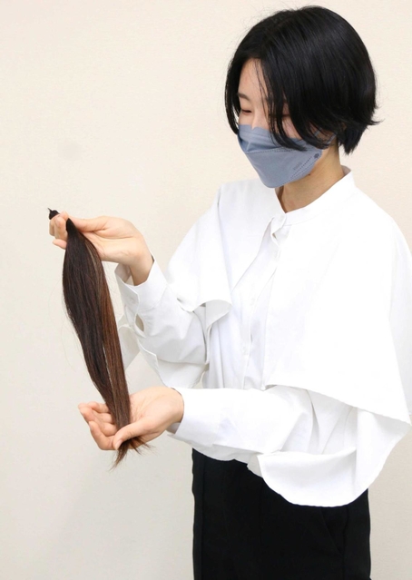カットした４０センチの髪を持つ筆者＝三田市三輪２