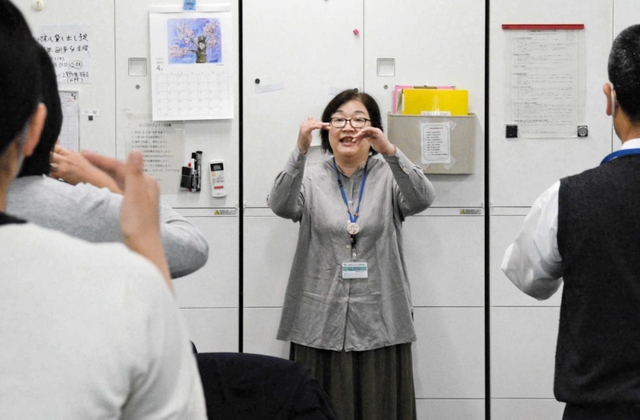 手話で朝礼を行う共生社会部福祉共生室の職員＝三田市役所
