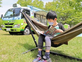 ハンモックの上で読書を楽しむ子ども＝三田市福島