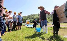 田んぼの水が漏れない仕組みを学ぶ児童ら＝三田市西相野
