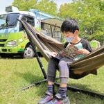 ハンモックの上で読書を楽しむ子ども＝三田市福島