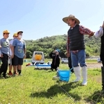 田んぼの水が漏れない仕組みを学ぶ児童ら＝三田市西相野