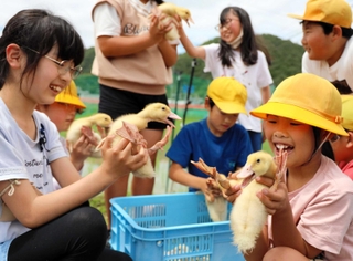 アイガモを持って喜ぶ児童たち＝三田市須磨田