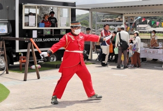 来場者の駐車をパフォーマンスとかけ声でサポートする「踊る警備員」の阪口亮さん＝三田市末