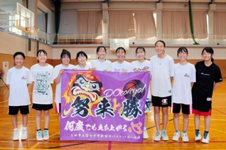 自分たちでデザインを手がけた横断幕を手にする富士中女子バスケットボール部員ら＝三田市富士が丘３