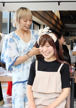 アドバイザーのえりこさん（左）に医療用ウィッグのアレンジを教わる参加者＝三田市富士が丘５